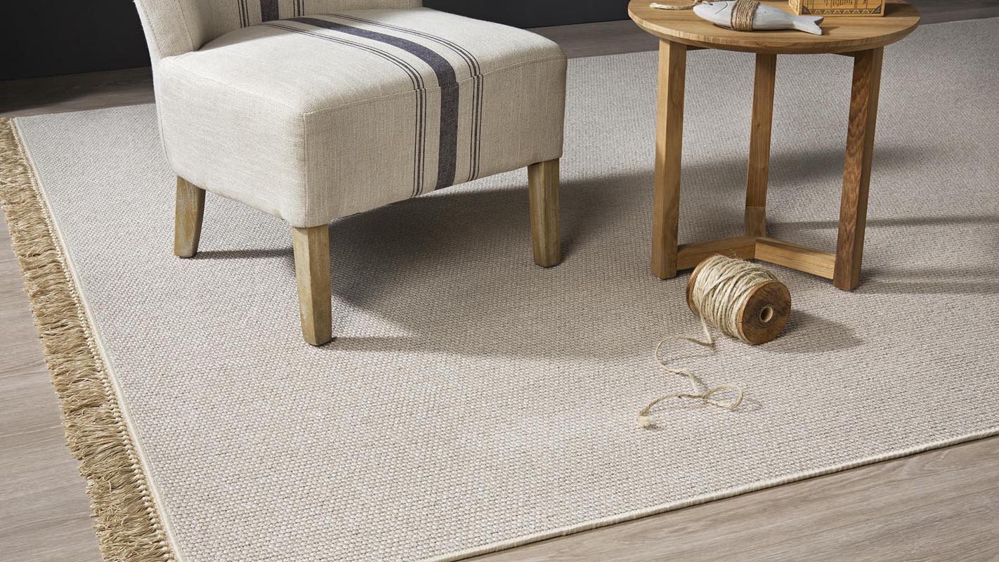 Sillón, mesa, y novillo de lana sobre alfombra de lana muy fina en color natural nakar kp alfombras a medida