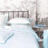 Ambiente con cama vestida con funda nórdica designers guild astor aqua