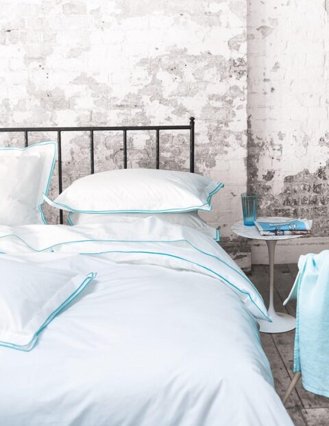 Ambiente con cama vestida con funda nórdica designers guild astor aqua