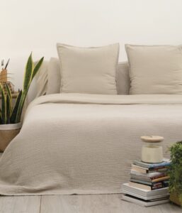 decoración cama en tonos beige, vestida con colcha Sisomdos doble gasa lino sobre funda nórdica. Diseño liso con cuadraditos pequeños irregulares.