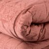 Detalle de edredón Saray Riviera, en terciopelo y color rosa. Revés en microfibra. Pespunteado a cuadros.