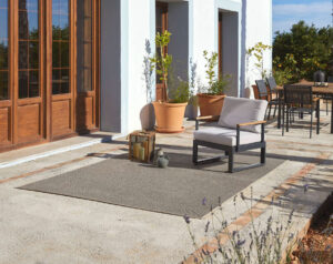 terraza suelo hormigón elegante con alfombra exterior rols terra, a medida, muebles comedor. Gris y blanco.