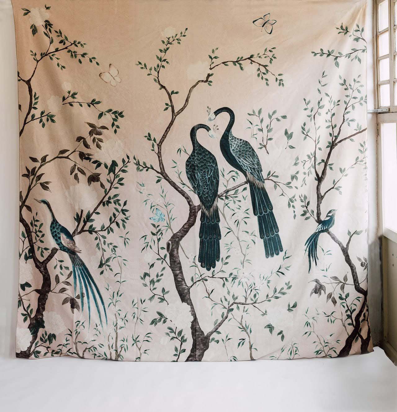 Colcha tapiz bonita Edo Coordonné colocado en pared, composición exótica pavos reales sobre ramas, fondo rosa. Algodón lino.