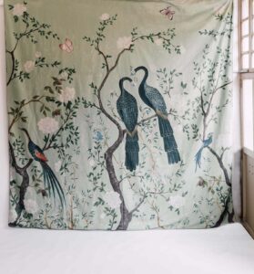 Colcha tapiz bonita Edo Coordonné colocado en pared, composición exótica pavos reales sobre ramas, fondo verde. Algodón lino.