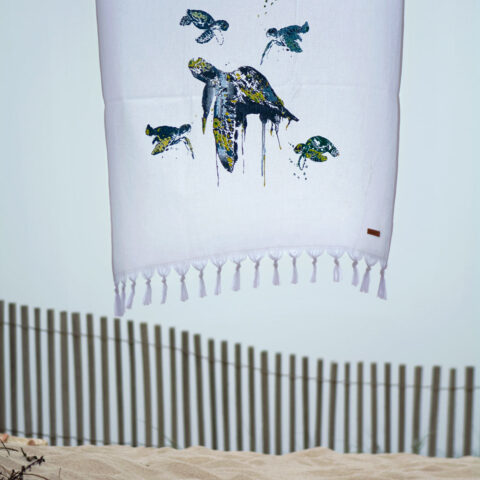 Toalla pareo playa Briciní Turtle con diseño de tortugas sobre fondo blanco. Comprar online toalla ligera, no se pegan arenas, algodón